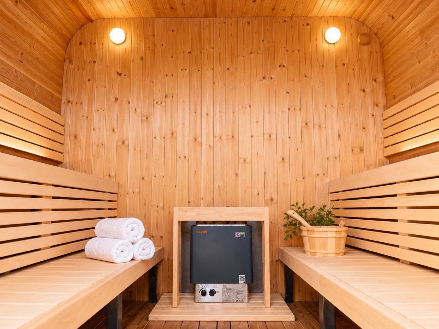Inside the cedar sauna at BV House, benches warm and lit
